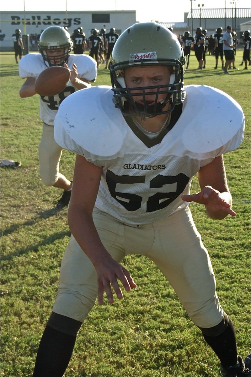 Image: Center Bailey Walton(52) takes a practice snap with quarterback Justin Wood(48) befor the game.