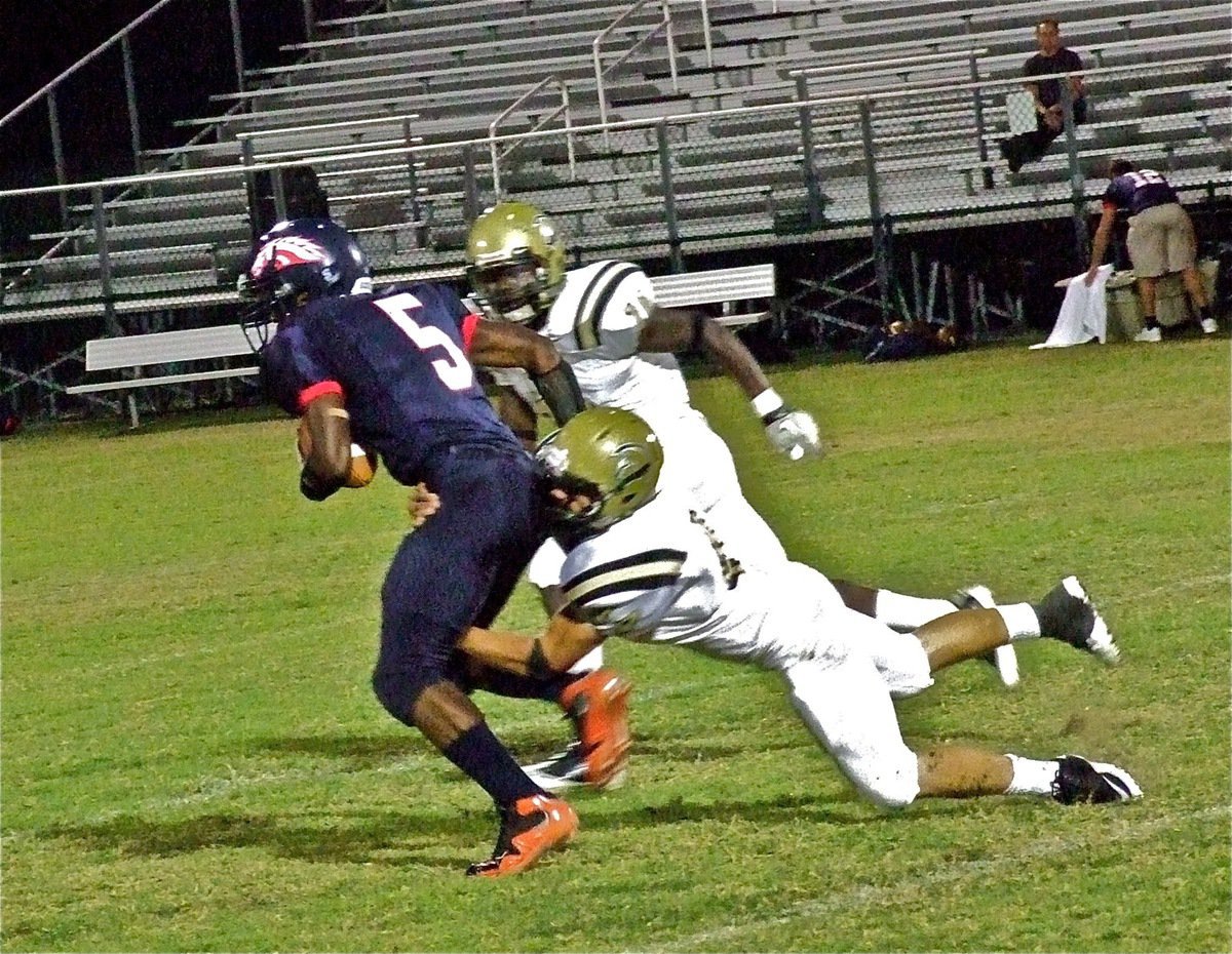 Image: Chase Hamilton(2) and Ryheem Walker(10) catch a Mustang, Shawn Foulks(5), running wild.