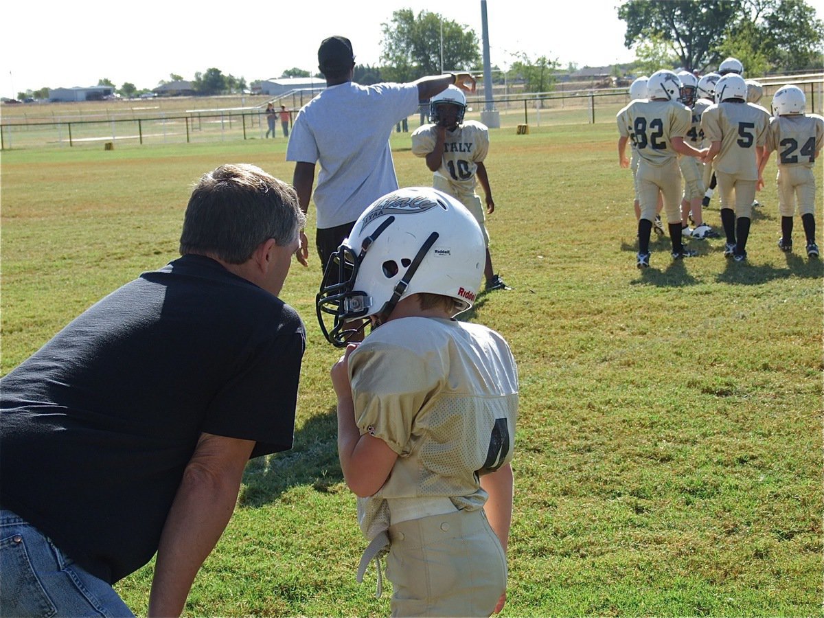 Image: IYAA B-team head coach Gary Wood sends in a play with Bryce DeBorde(4).