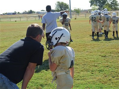 Image: IYAA B-team head coach Gary Wood sends in a play with Bryce DeBorde(4).