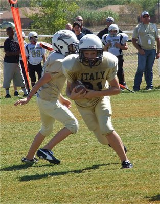 Image: Clay Riddle(31) takes the handoff from Ryder Itson(7) and races around the right side of the defense for his first career touchdown. His father, Curtis Riddle, commented after the play, “Resembles his uncle.” (Referring to Clint “Crazy Legs” Riddle who was a fierce running back for the Gladiators before graduating in 1987 who helped lead Italy’s varsity to a 14-1 record his senior season.)