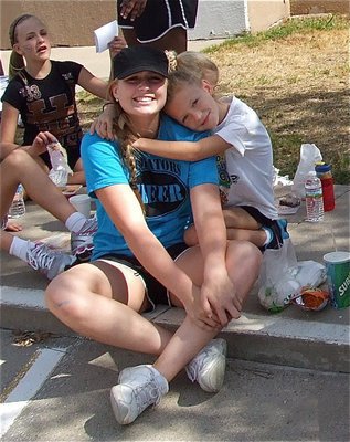 Image: IYAA cheerleader Karley Sigler embraces IHS cheerleader Madison Washington.