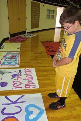 Image: IYAA B-Team football star Gage Wafer admires the handy work created by the IYAA cheerleaders during the camp.