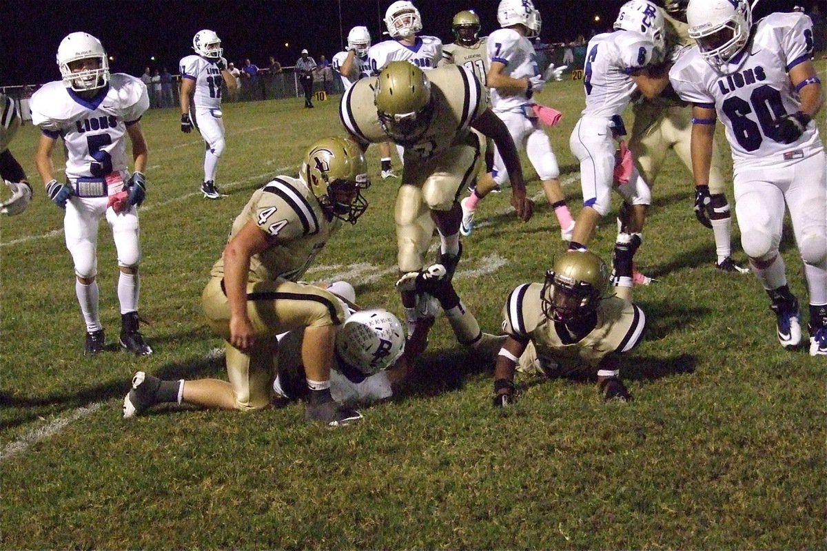 Image: Ethan Saxon(44), Paul Harris(7) and Eric Carson(24) bring down a Lion.