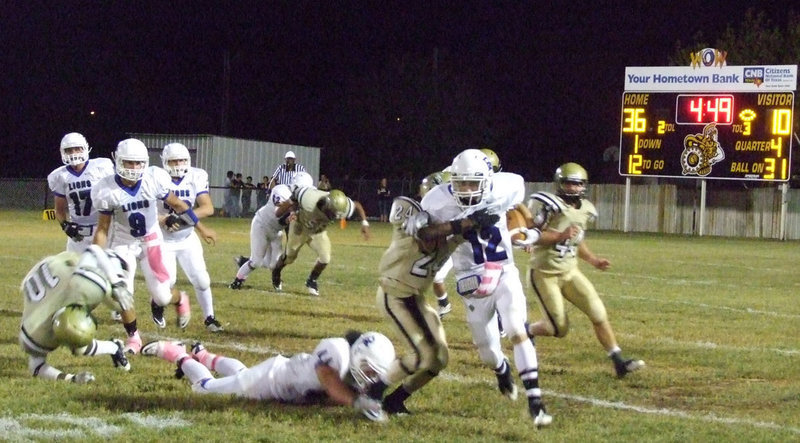 Image: Cornerback Eric Carson(24) takes a Lion runner down.