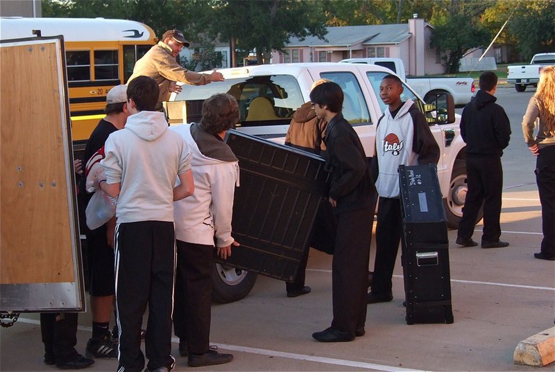 Image: Italy ISD School Board member, Larry Eubank, helps band members get their musical gear loaded.