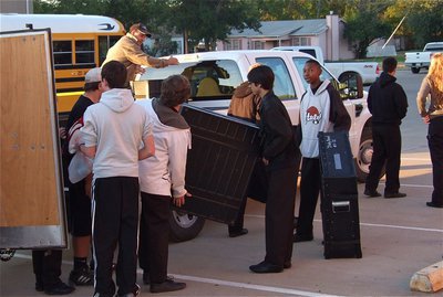 Image: Italy ISD School Board member, Larry Eubank, helps band members get their musical gear loaded.