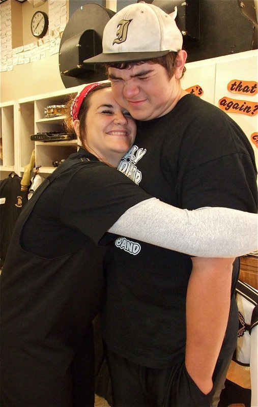 Image: It’s good to have all the muscles on a cold day. Kaytlyn Bales uses fellow band buddy Kevin Roldan as an electric blanket.