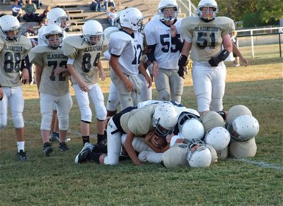 Image: And down he goes! Several Gladiators bring down a Cougar runner.