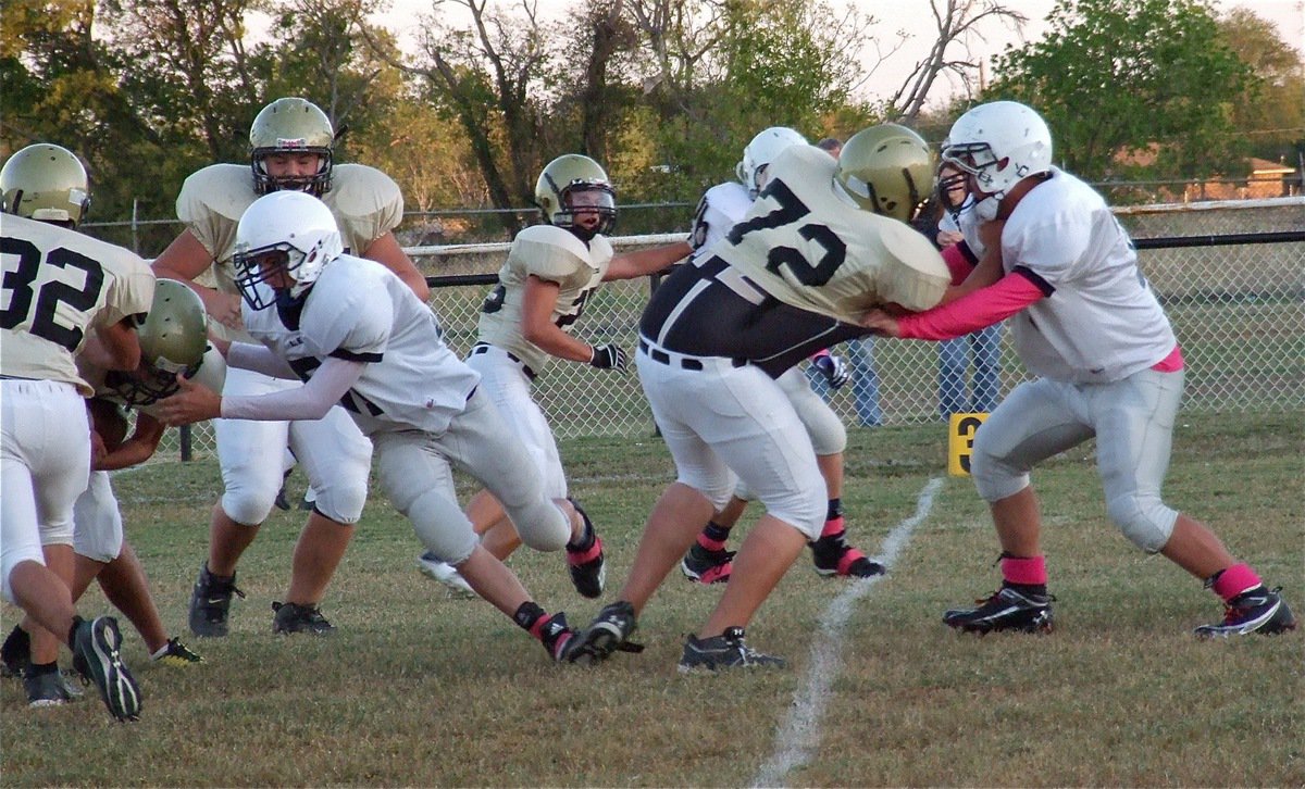 Image: Cody Medrano(32), Kelton Bales(75), Shad Newman(25) and Colin Newman(72) help teammate Justin Wood(48) punch thru Leon’s defenses.