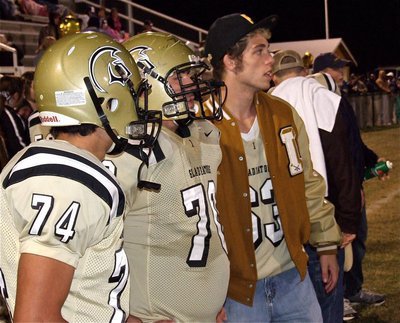 Image: Braulio Luna(74), Isaac Medrano(70) and Brandon Souder(63) discuss the game’s happenings from the Gladiator sideline.