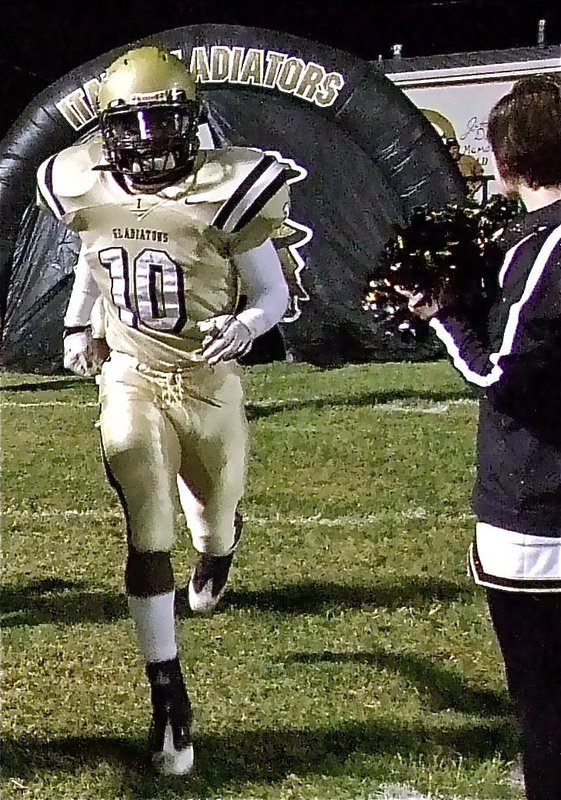 Image: IHS cheerleader Meagan Hooker cheers on Ryheem Walker and the Gladiators as they exit the tunnel to take on the Axtel Longhorns.