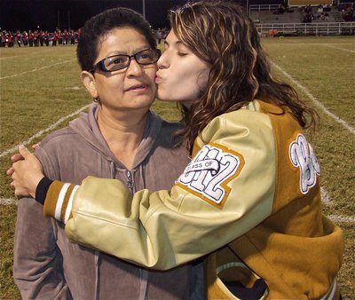 Image: Senior IHS cheerleader, Beverly Barnhart, gives her mom a kiss during their introductions.