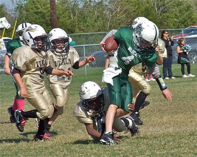 Image: Eric Martinez(5), Ty Cash(24) and Ricky Pendleton(21) go after a Wildcat runner.