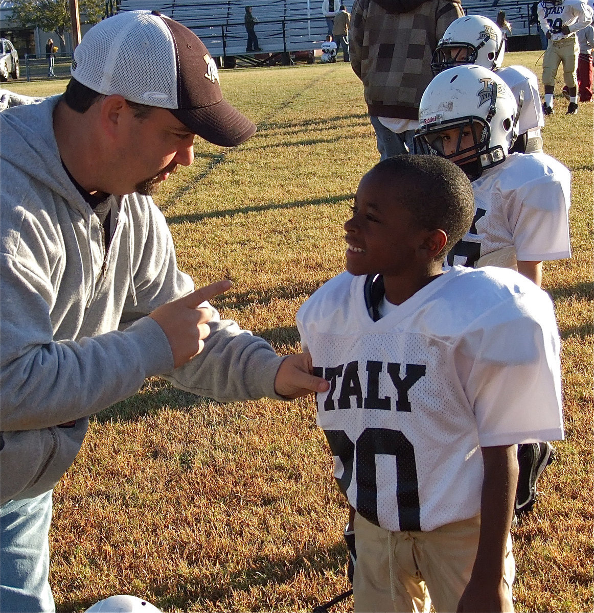 Image: Before their game against Dawson, IYAA C-Team assistant coach, Barry Byers, tells Darrin Jackson(30) that Jackson would score a touchdown on his first carry of the game. 55-yards later, Jackson did just that in the third-quarter.