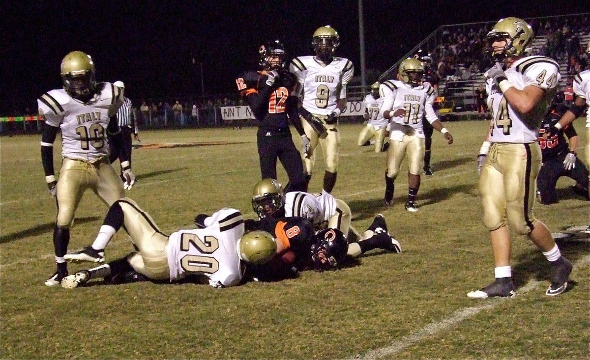 Image: Italy’s Trevon Robertson(20) and Eric Carson(24) bring down a Tiger runner.