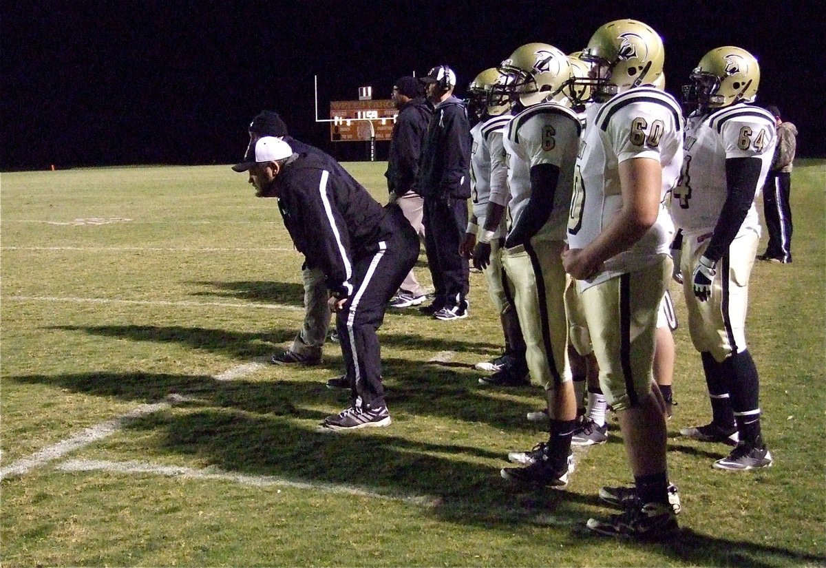 Image: Gladiator head coach Craig Bales uses his old linebacker stance to view the play.