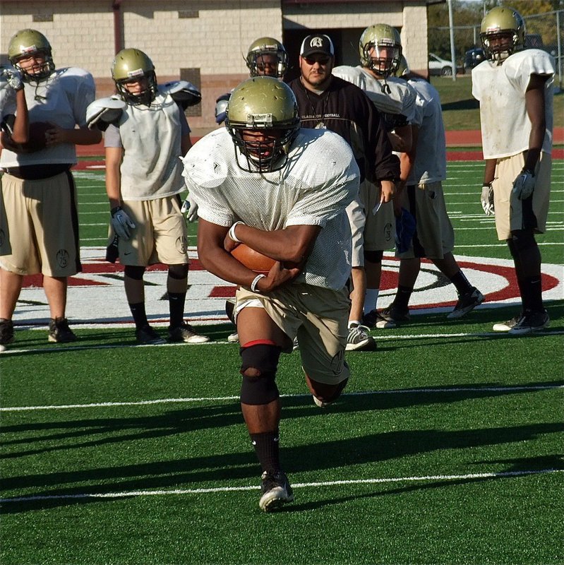 Image: Jalarnce Lewis hits the hole during practice as Coach Bales looks on.