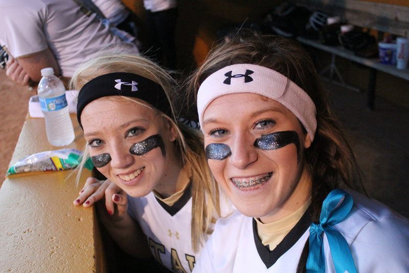 Image: Seniors, Megan Richards and Bailey Bumpus cheer on their teammates. 