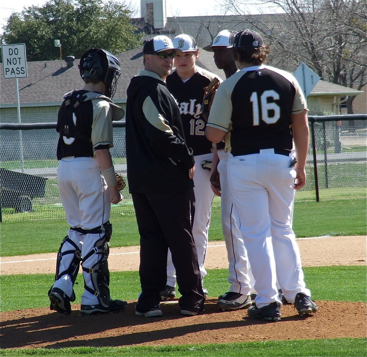 Image: JV Gladiator head coach Josh Ward checks on his pitcher, Marvin Cox(1), as do catcher John Escamilla(3), third baseman John Byers(12) and first baseman Kevin Roldan(16).