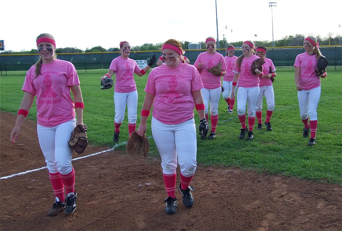Image: A field of pink, the Lady Gladiators head in to the dugout.