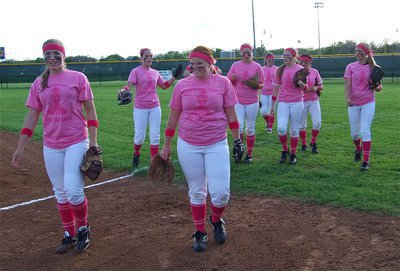 Image: A field of pink, the Lady Gladiators head in to the dugout.