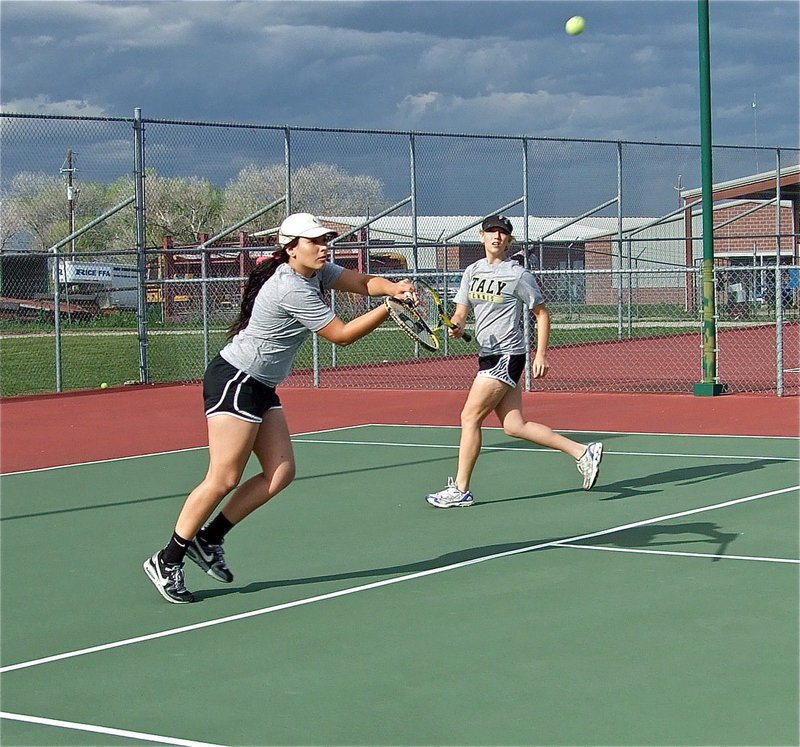 Image: Alyssa Richards returns the ball while Megan Richards backs her little sister up.