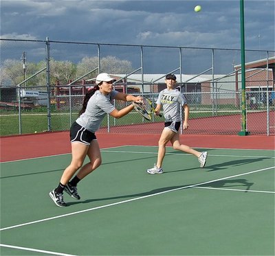 Image: Alyssa Richards returns the ball while Megan Richards backs her little sister up.