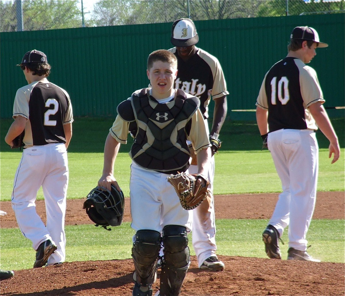 Image: Catcher John Escamilla(5) returns to his office after a meeting with Chace McGinnis(2), Marvin Cox(1) and Zain Byers(10).