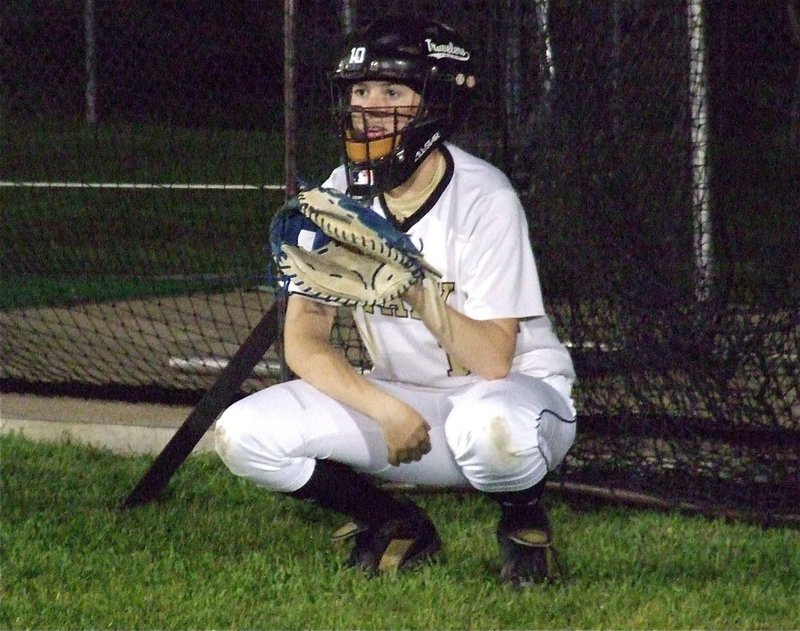 Image: Kelsey Nelson, puts on the catcher’s mask to warm the pitching arm of teammate, Megan Richards. 