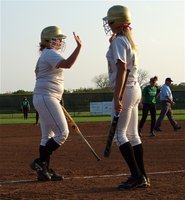 Image: Katie Byers(13) and teammate Megan Richards(17) high-five after Byers crossed home plate.