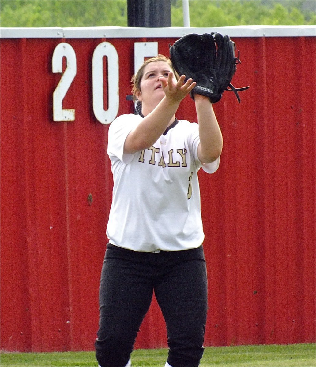 Image: Lady Gladiator, Brooke DeBorde, shags fly balls during pre-game drills.