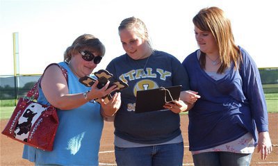 Image: Senior Lady Gladiator  manager, Drenda Burk, admires her wooden cross along with her escorts, mother, Trish Burk, and schoolmate, Emily Stiles.