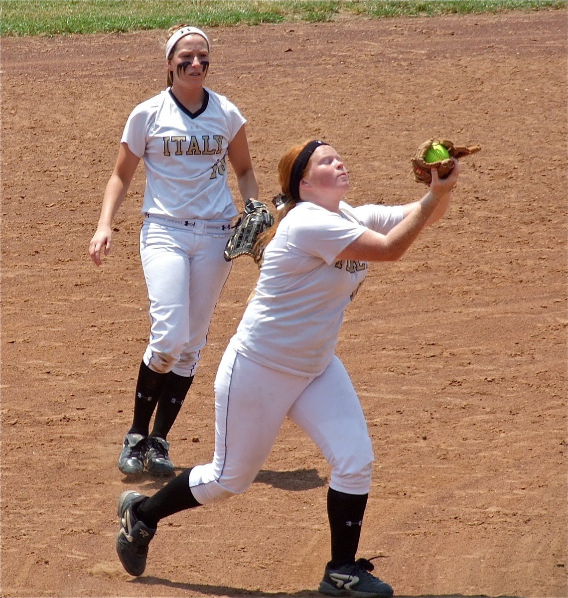 Image: Katie Byers(13) uses the force to haul in a popup at third base as Bailey Bumpus(18) backs her up.