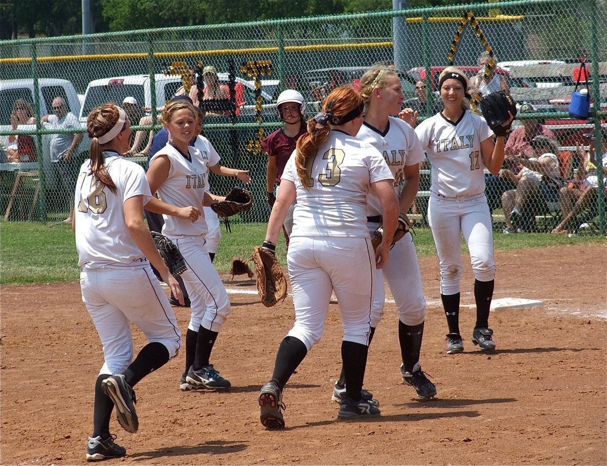 Image: Italy’s, Katie Byers(13) fields a grounder and throws to Megan Richards(17), at first base to end game 2 and complete the sweep of Mildred for the AA Area Championship before celebrating with her teammates.