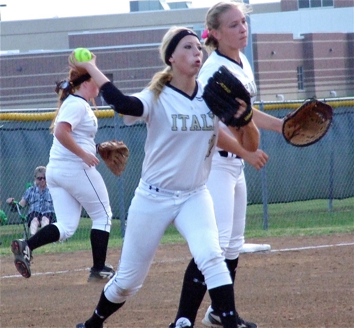 Image: Megan Richards(17) and Jaclynn Lewis(15) converge on a bunt with Richards making the throw to first for the out.