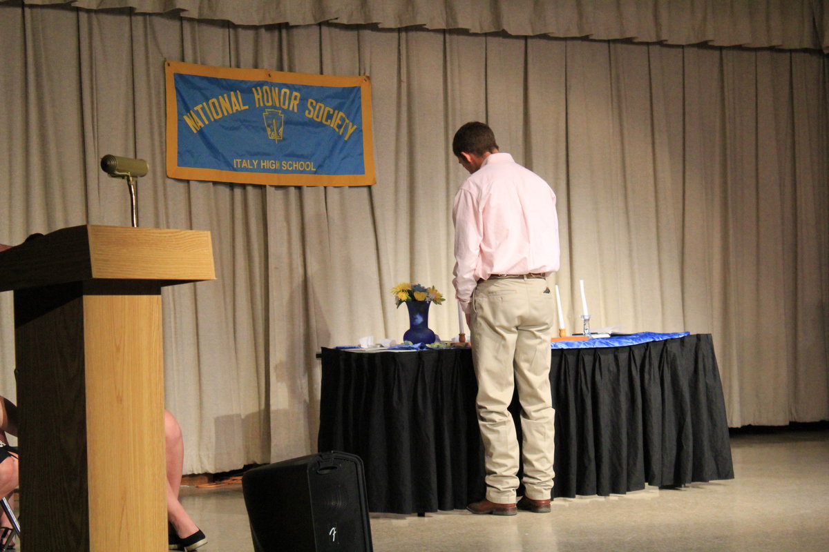 Image: Brandon Souder lights the “Service” candle.
