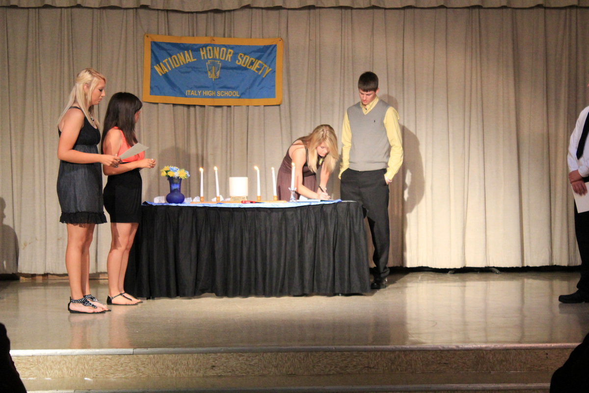 Image: Taylor Turner (sophomore) signs the NHS book.