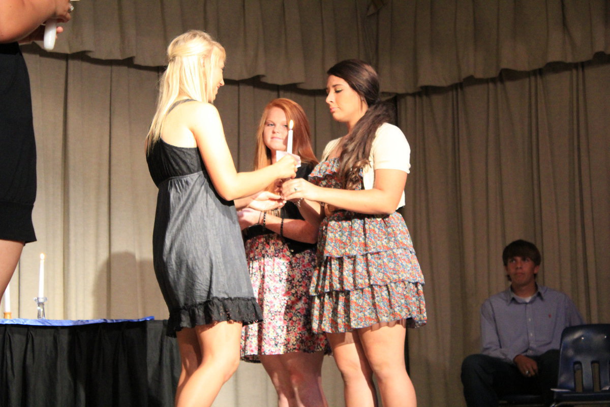 Image: Vice President, Megan Richards (senior) passes her flame down to sister, Alyssa Richards (junior).