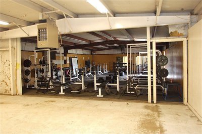 Image: Lockers are stripped out and a wall is torn down revealing the weight room.