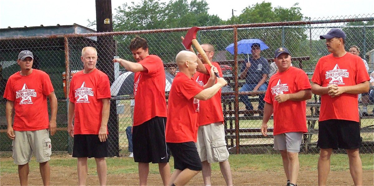 Image: Italy Firefighter Michael Chambers helps get the mojo going as he hustles down the line with the battle axe.