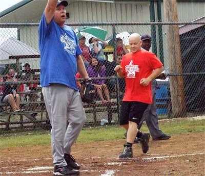 Image: Police Chief Diron Hill yells for his teammate to hold the ball as firefighter Michael Chambers makes his way home.
