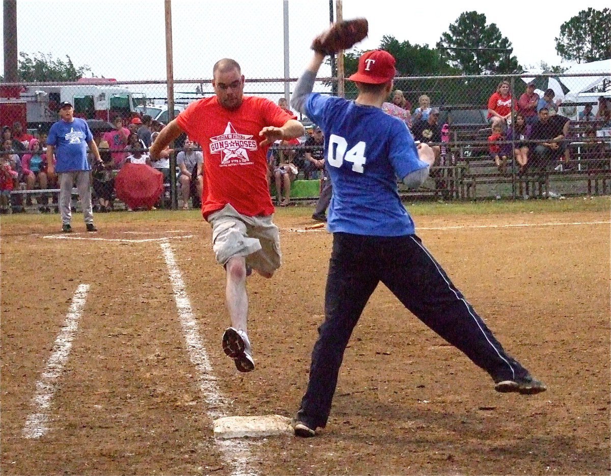 Image: Officer Daniel Pitts(04) makes the catch at first base to get Firefighter Brad Chambers out to end the exciting matchup.