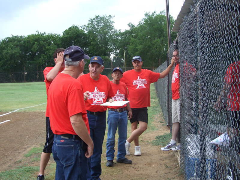 Image: Chief Donald Chambers goes over the batting order with the team members.