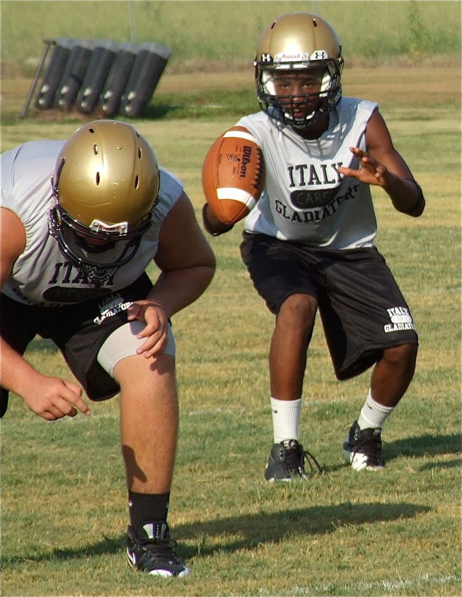 Image: Kevin Roldan works at right guard while Eric Carson takes the snap at quarterback.