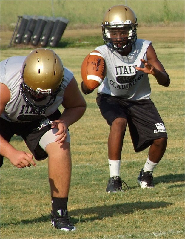 Image: Kevin Roldan works at right guard while Eric Carson takes the snap at quarterback.