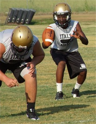 Image: Kevin Roldan works at right guard while Eric Carson takes the snap at quarterback.