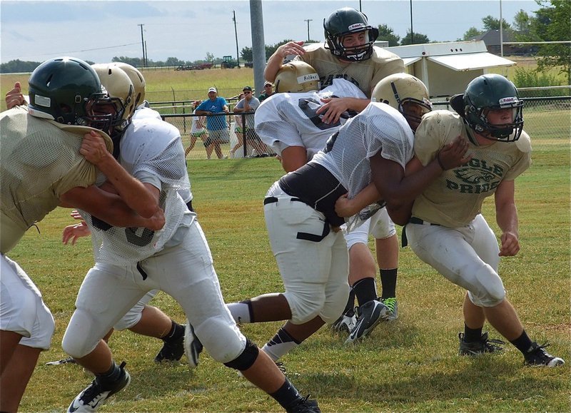 Image: The battle in the trenches is not for the weak hearted as Zackery Boykin(55), Darol Mayberry(58) and Kevin Roldan(60) take on the challenge.