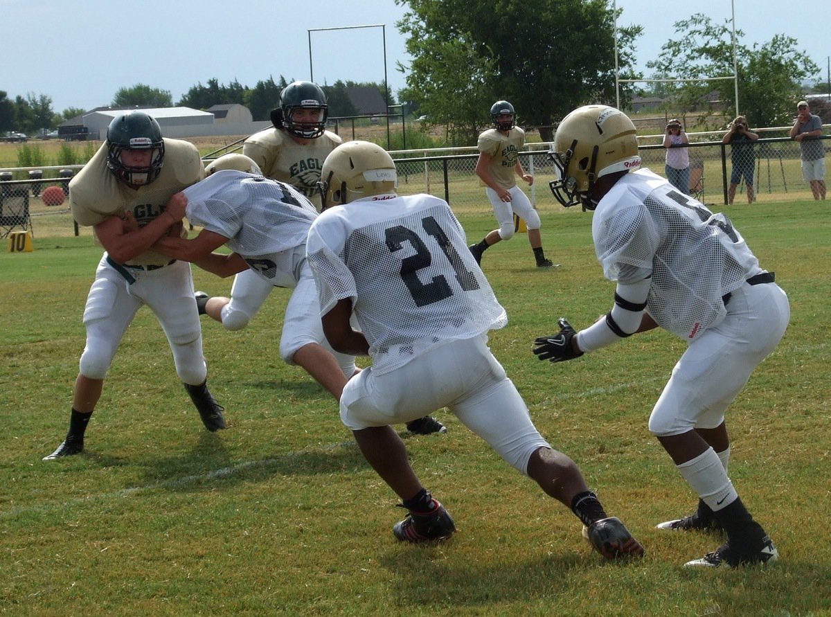 Image: Right tackle Cody Medrano(75) tries to give Jalarnce Jamal Lewis(21) a crease to run thru after Lewis takes the handoff from Eric Carson(5).