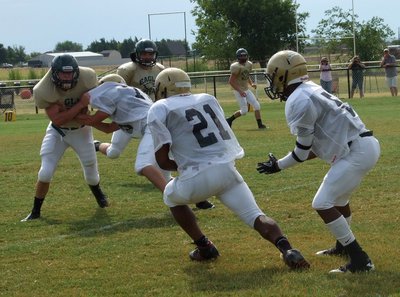Image: Right tackle Cody Medrano(75) tries to give Jalarnce Jamal Lewis(21) a crease to run thru after Lewis takes the handoff from Eric Carson(5).